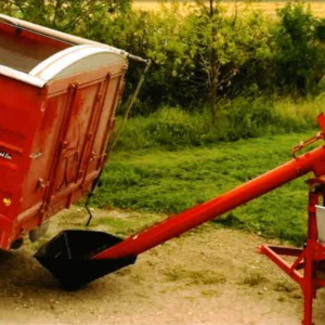 une vis utilitaire de manutention de grain qui rempli avec un fond forêt